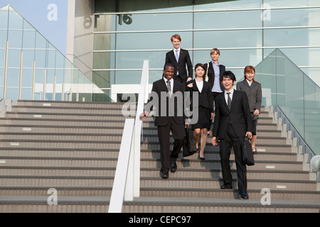 Businessmen and businesswomen getting down steps Stock Photo