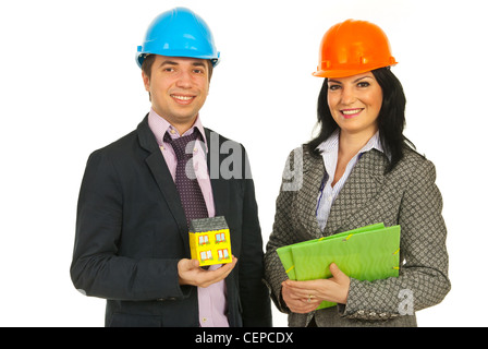 Two happy architects holding miniature house and folders isolated on white background Stock Photo