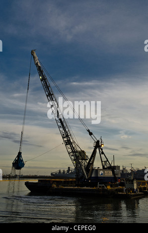 Crane dredge barge performing environmental clean up in the Seaplane Lagoon at Alameda Naval Air Station Stock Photo