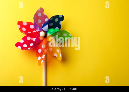 Childrens colorful windmill toy isolated on yellow background Stock Photo
