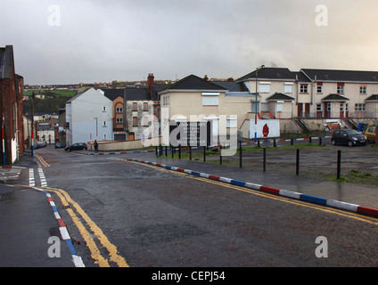 A defiant sign and kerb stones painted in red, white and blue in the Protestant area of Derry, Londonderry, Northern Ireland. Stock Photo