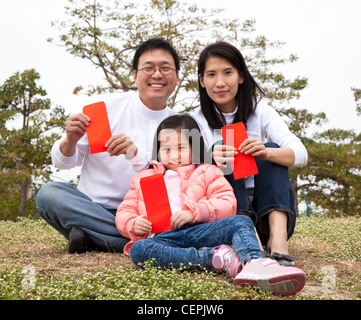 Happy chinese family holding red envelop celebrating chinese new year