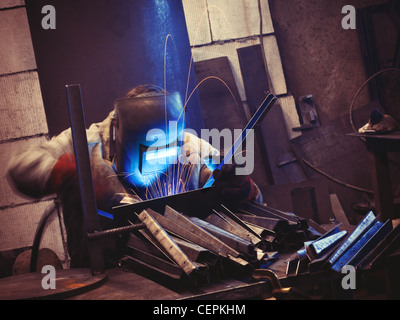 Worker in the factory making welding work Stock Photo