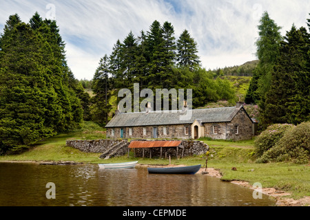 Remote Loch Ordie, nr Dunkeld, Scotland with old stone cottages, row boats & boat house by shore Stock Photo