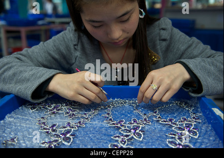 Liyao, from Xi'an, Shannxi, make fashion broochs in Zhejiang Neoglory Jewelry Co., Ltd. in Yiwu, Zhejiang, China.  07-Nov-2011 Stock Photo