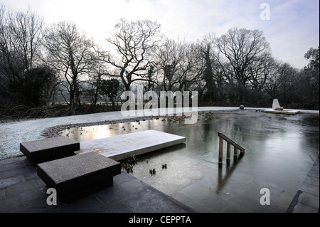 A natural swimming pool which has iced over in winter UK Stock Photo