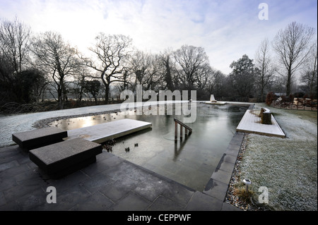 A natural swimming pool which has iced over in winter UK Stock Photo