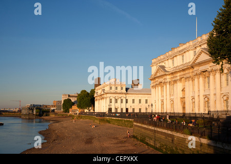 People walking past the Old Royal Naval College by the River Thames on a summer evening. Stock Photo