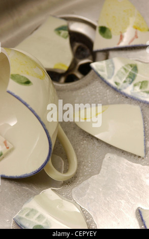 Detail of broken blue cup in stainless steel sink Stock Photo