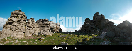 Panoramic view of a couple walking between the large granite outcrops of Hound Tor on Dartmoor. Stock Photo