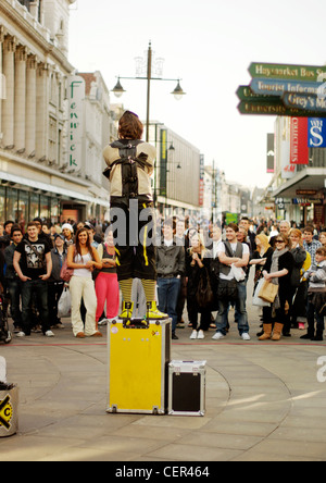 An escapologist standing on a box performing to a crowd on Northumberland Street. Stock Photo
