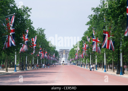 Flags flutter in the breeze on the Mall leading up to Buckingham Palace. Stock Photo