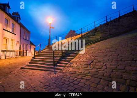 A traditional street light illuminates the 199 steps leading down towards the old town of Whitby. Stock Photo