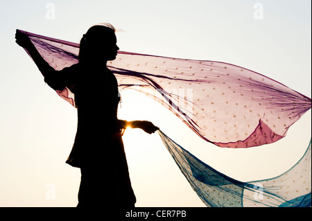 Indian girl with star patterned veils in the wind. Silhouette