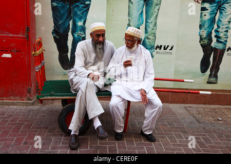 Two Arab men sitting on a bench in the Dubai Gold Souq Stock Photo ...