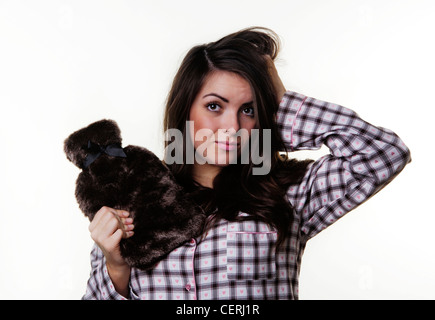 woman wearing pajamas and holding a nice hot water bottle getting ready to go to bed Stock Photo