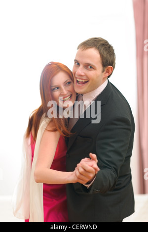 Formally dressed happy couple having fun dancing Stock Photo