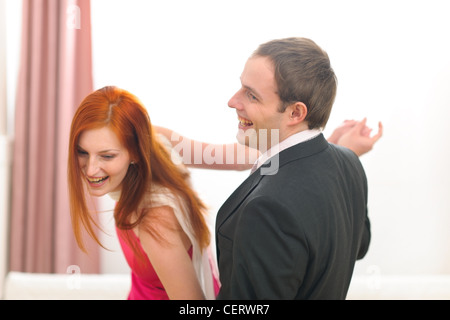 Formally dressed cheerful couple having fun dancing Stock Photo