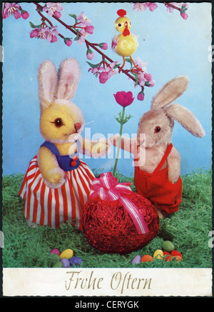 Postcard printed in Germany, shows bunnies, flower, branch, chickens and an Easter egg, circa 1982. German text: Happy East Stock Photo