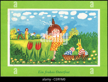 Postcard printed in the GDR, shows a little girl, painted eggs, bunny, circa 1980. German text: Happy Easter. Stock Photo