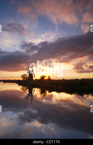 Turf Fen Windmill on the Norfolk Broads reflecting in the River Ant at sunset. Stock Photo