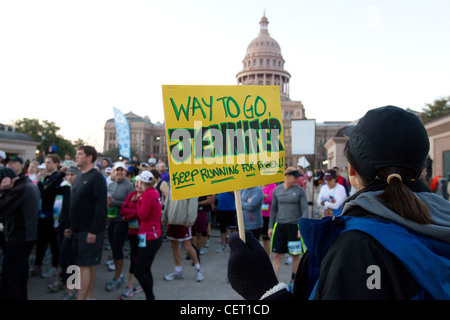 More than 18,000 runners pounded the streets of downtown Austin for annual marathon. Woman holds encouraging sign Stock Photo