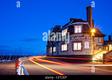 Light trails from cars passing the Blakeney Hotel on the Norfolk Coast at dusk. Stock Photo