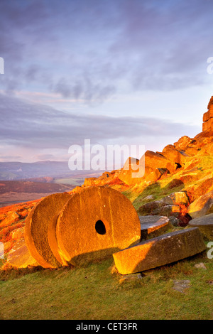 Abandoned millstones beneath Stanage Edge at first light in the Peak District National Park. Stock Photo