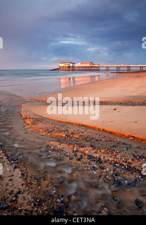 Stormy light over Cromer Pier shortly before sunset on the North Norfolk Coast. Stock Photo