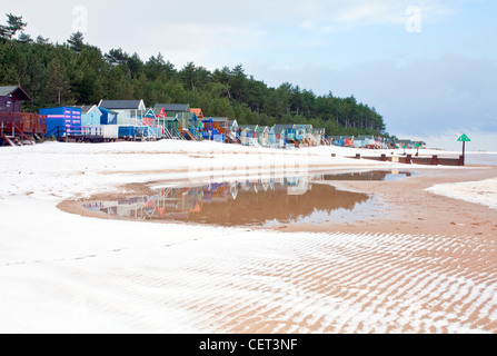 The famous colourful beach huts at Wells-next-the-Sea following winter snowfall on the Norfolk Coast. Stock Photo