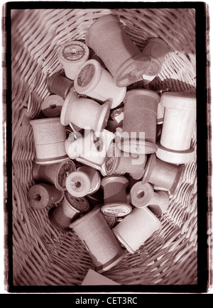 Thread spools empty in basket.  Still life vertical photo sepia toned. At Street Fair antiques, sewing shapes wood graphic Stock Photo