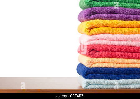 Stack of colorful microfiber towels on a table against white background Stock Photo