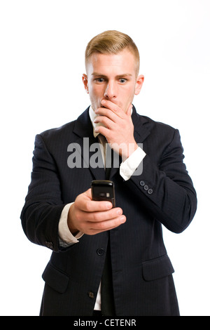 Elegant young businessman staring at his phone with shocked facial expression. Stock Photo
