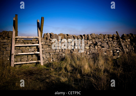 Small wooden steps over an old dry stone wall in Swaledale. Stock Photo