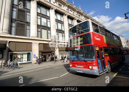 A red bus travels down Oxford Street. The development of Oxford Street as a prime shopping area began at the start of 20th centu Stock Photo