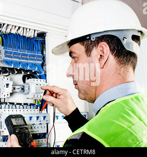 Electrician checking a fuse box Stock Photo