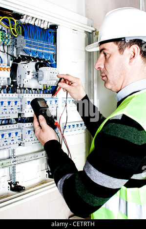 Electrician checking a fuse box Stock Photo