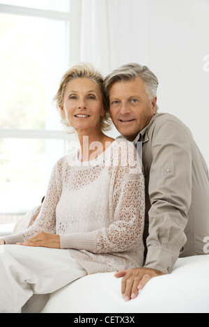Mature couple sitting together on bed, portrait Stock Photo