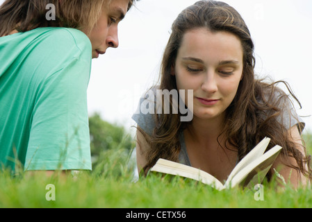 Young couple reading book together outdoors Stock Photo