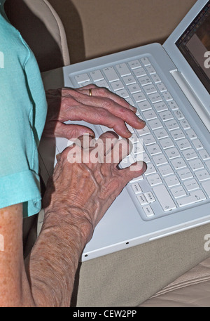 Hands of an elderly lady using a laptop computer Stock Photo