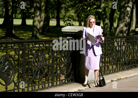 young woman reading in a park enjoying summer sun Stock Photo