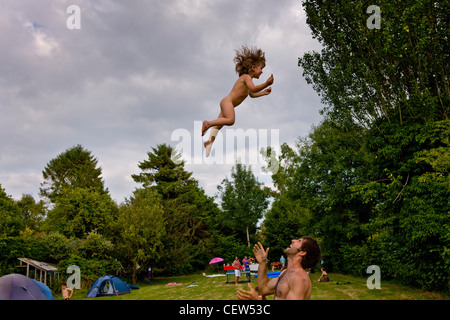 Child being thrown in the air on a family holiday Stock Photo