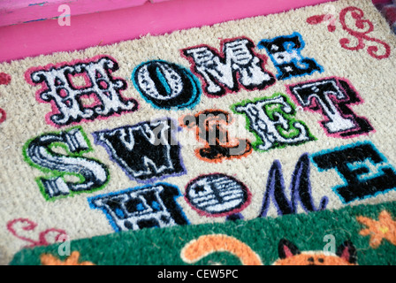 The words ' Home Sweet Home ' on one of several doormats displayed outside a shop Stock Photo