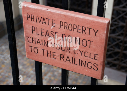 A notice reading: ‘ Private property. Please do not chain your cycle to the railings ‘ Stock Photo