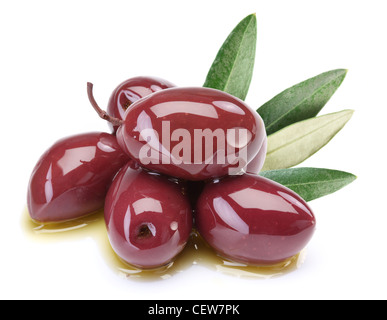 Purple olives in oil with leaves on a white background. Stock Photo