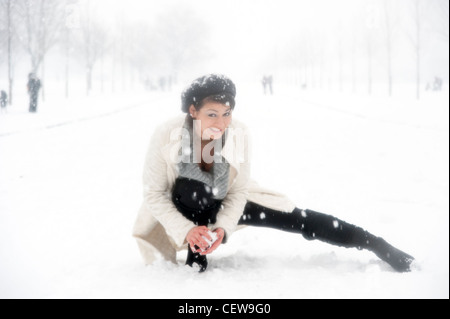 Young woman throwing snowballs in the snow, London, England, UK Stock Photo