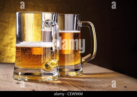 Two beer mugs close-up on wooden table Stock Photo