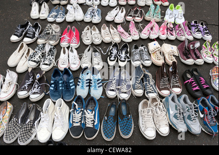 Old secondhand plimsoles for sale on market stall in Brick Lane, London, England, UK Stock Photo