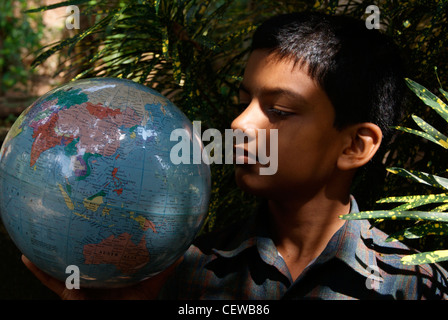 A Boy Looking Places from Earths Globe holding in hands Stock Photo