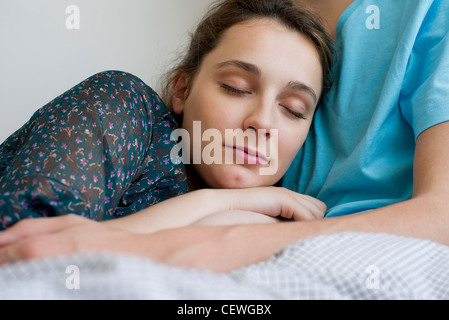 Young woman napping with head resting on man's chest Stock Photo
